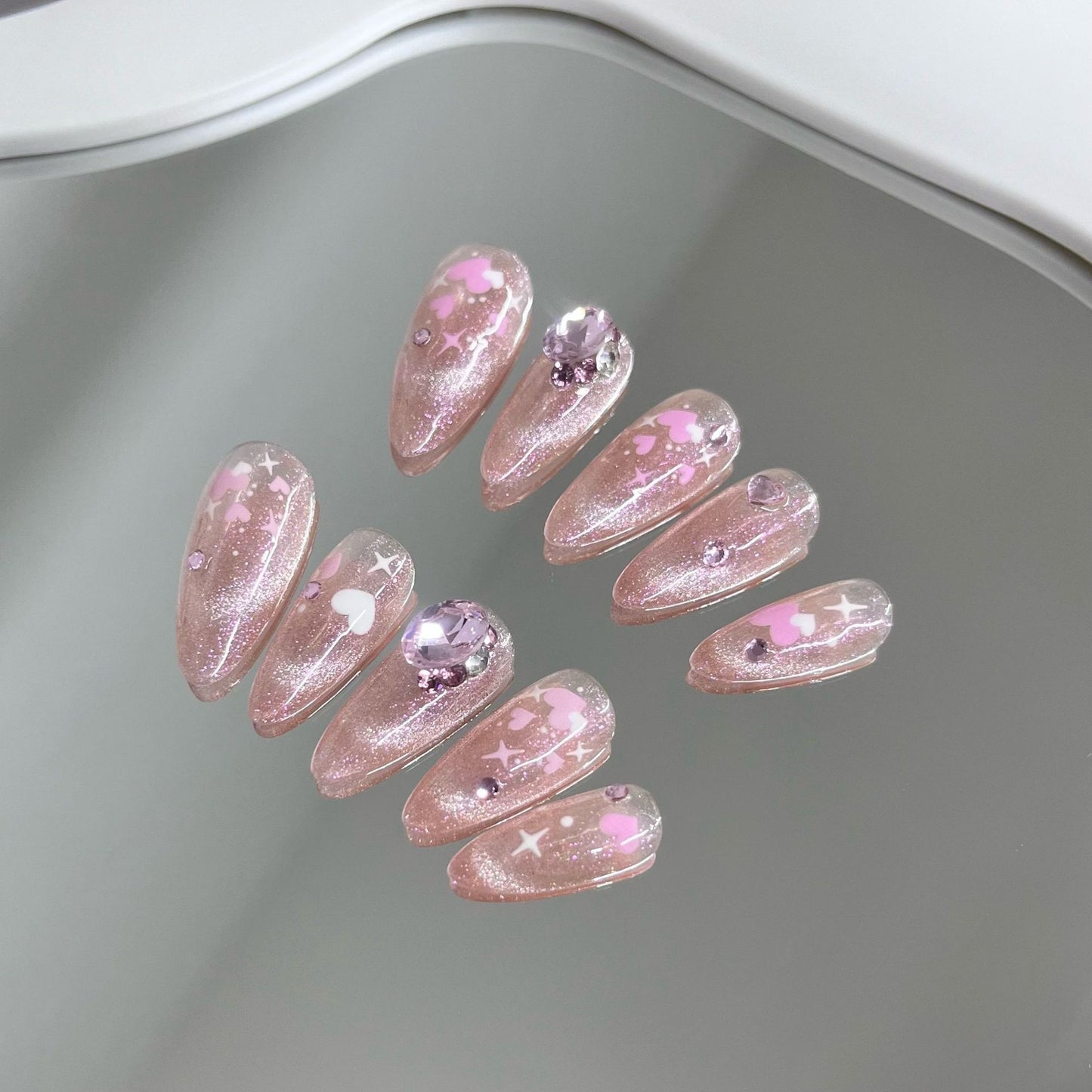 Nail art fait main avec un chat rose et une sensation de transparence