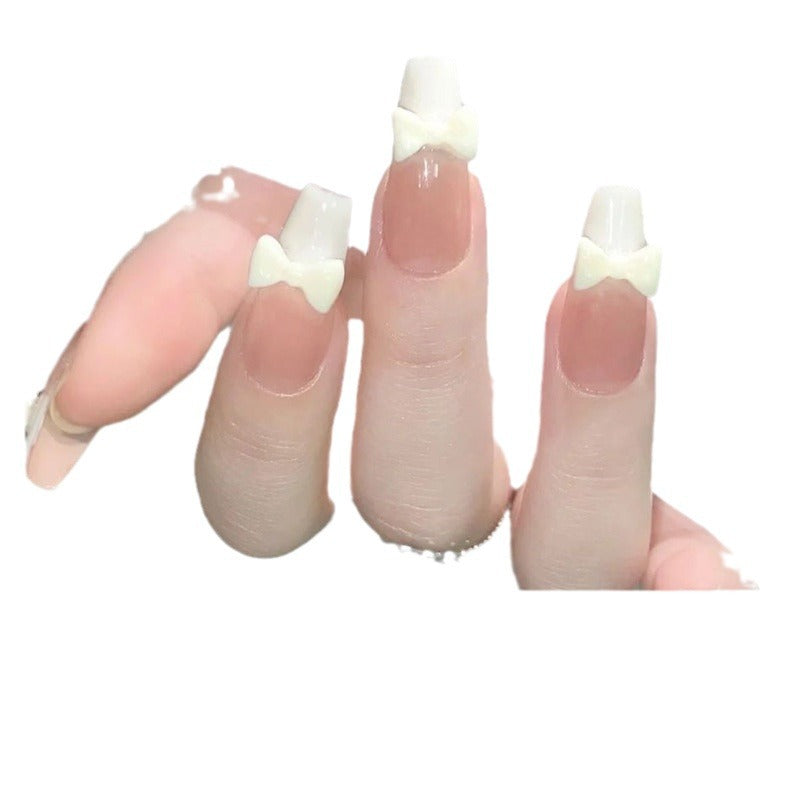 Nail Art fini avec un patch à nœud de style français blanc laiteux