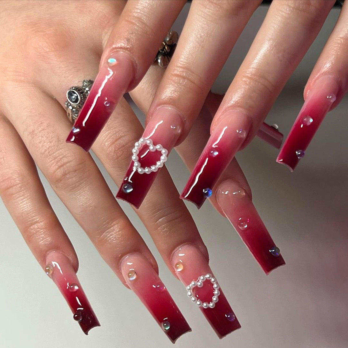 Manucure longue dégradée avec pointe de vernis à ongles rouge vin