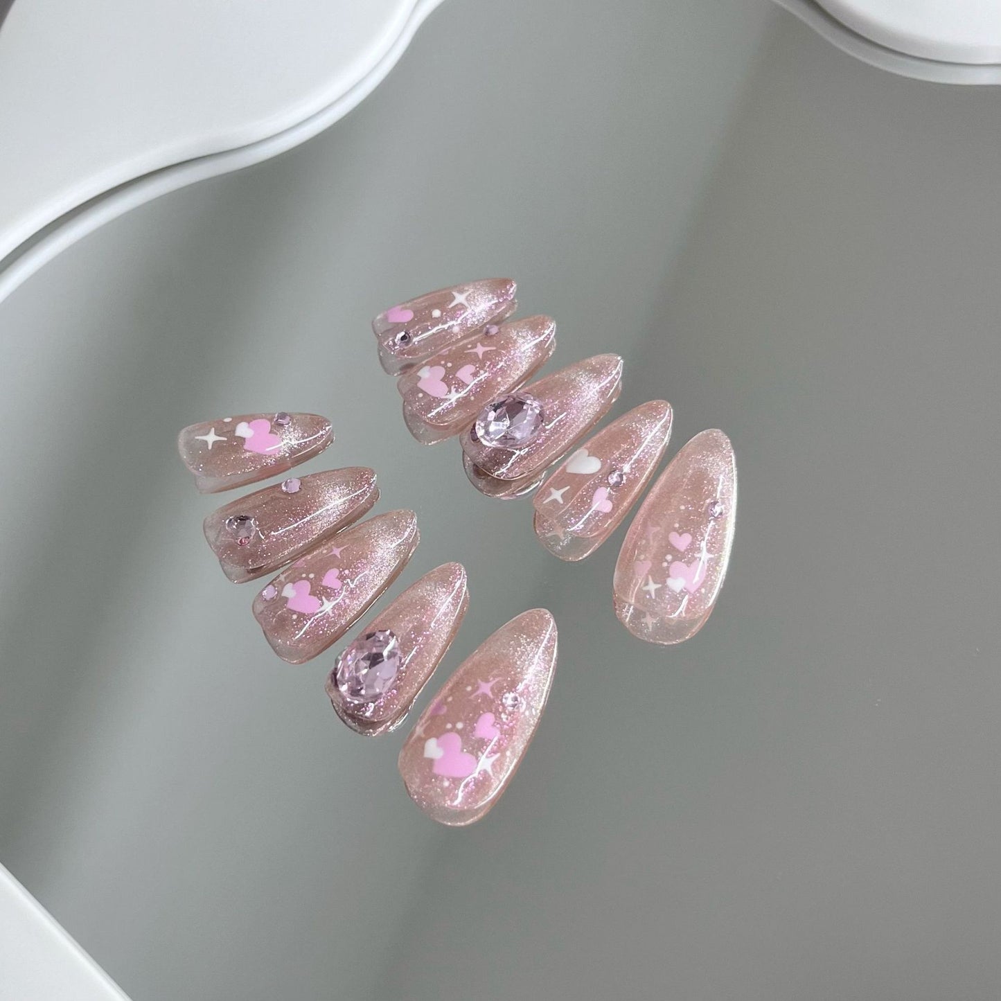 Nail art fait main avec un chat rose et une sensation de transparence