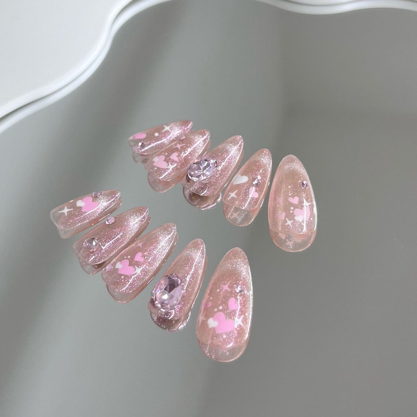 Nail art fait main avec un chat rose et une sensation de transparence