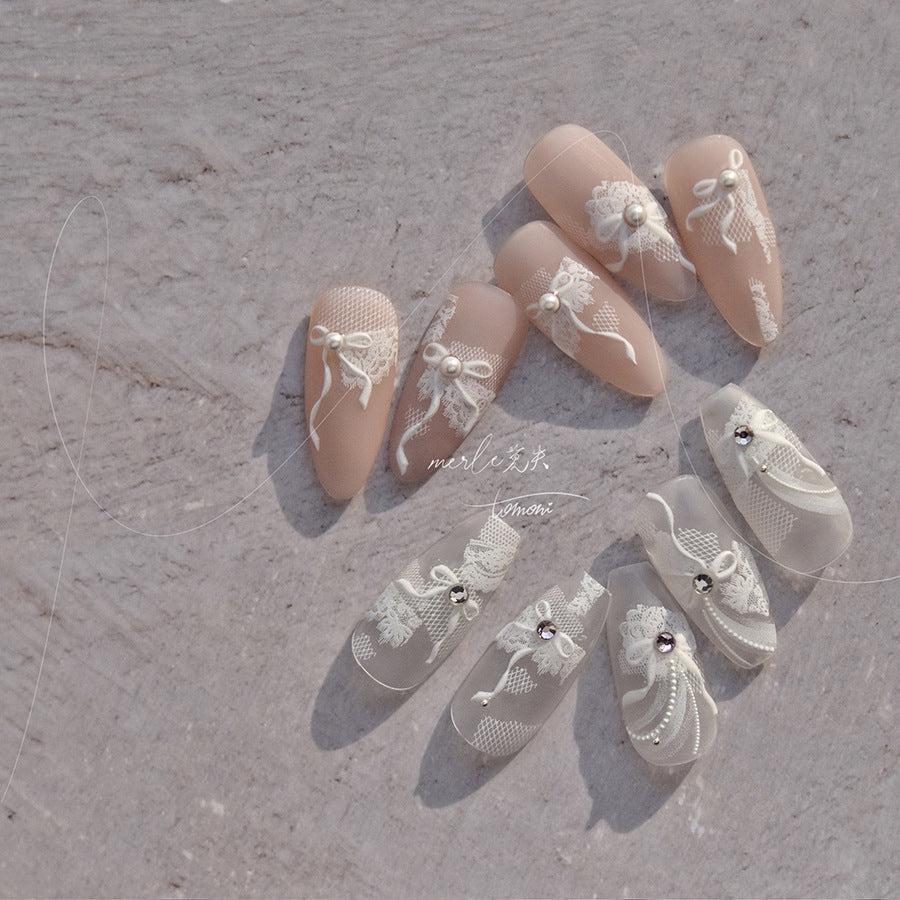 Avec du ruban adhésif, des autocollants pour ongles en dentelle de mariage blanche