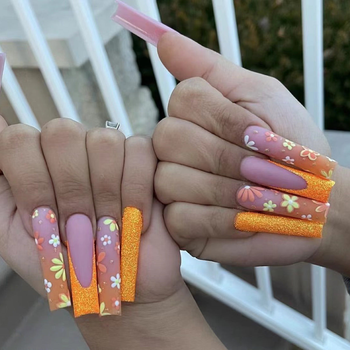 Manucure française mate orange avec patch de petites fleurs colorées et nail art fini