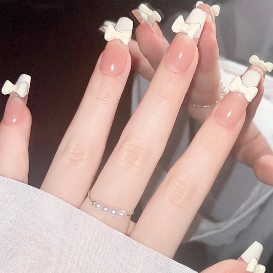 Nail Art fini avec un patch à nœud de style français blanc laiteux