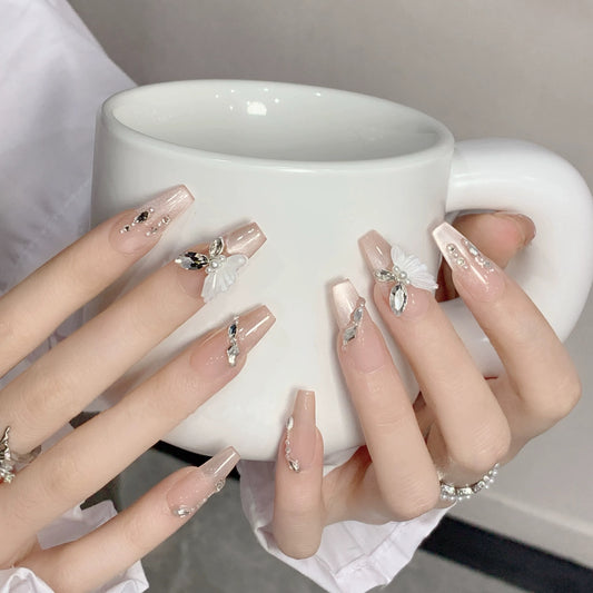 Nail art fait main avec un papillon, une fée et un chat portant un diamant